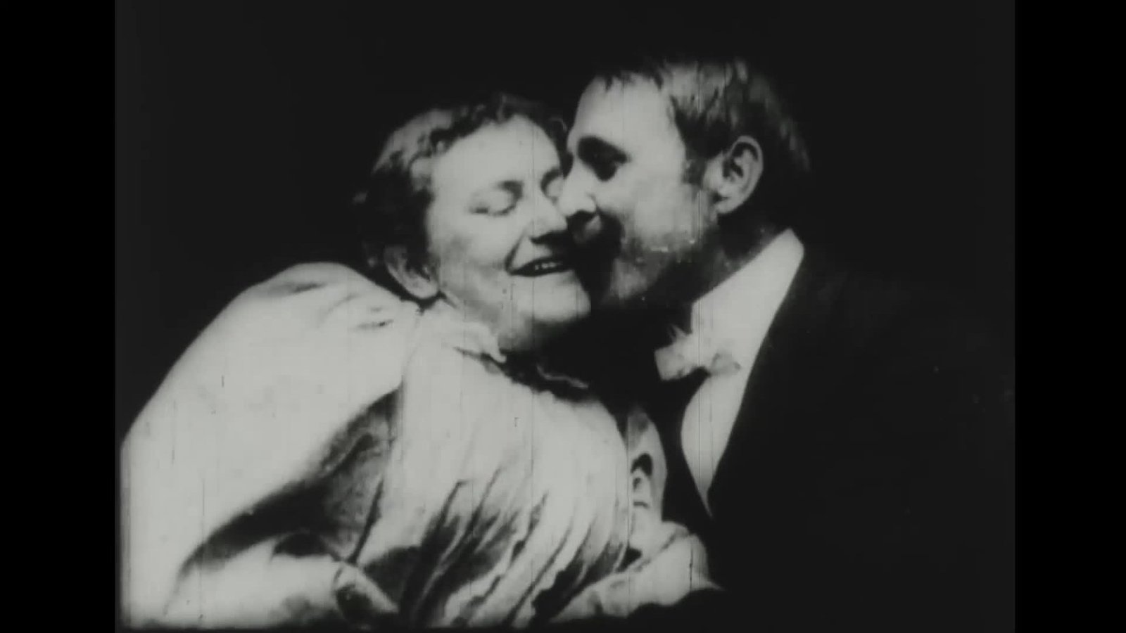 Black-and-white frame of actors May Irwin and John C. Rice sharing a staged kiss in an 1896 Edison film.