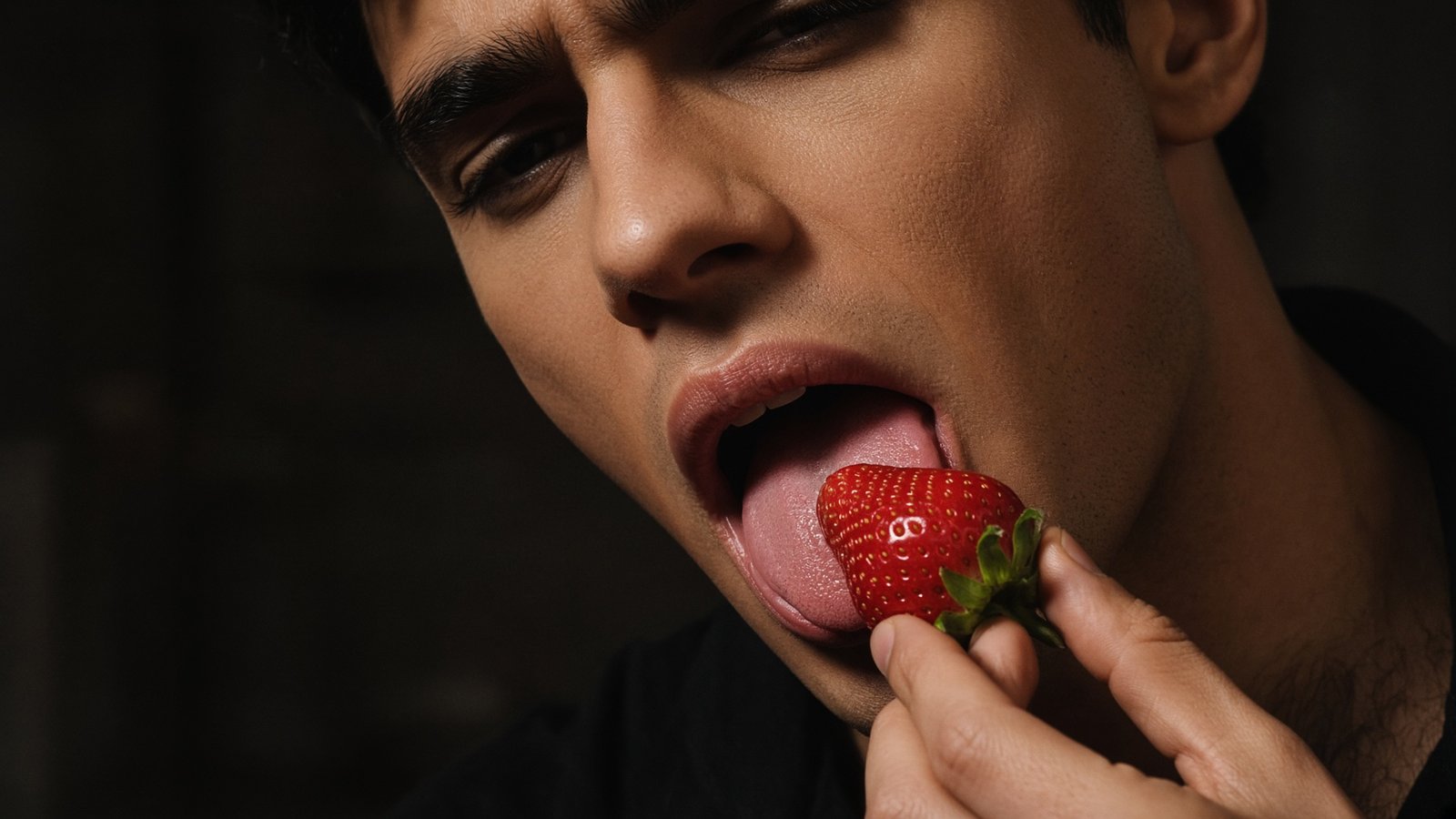 Close-up of a fictional adult man tasting a strawberry, illustrating the difference between food imagery and evidence-based sexual health claims.