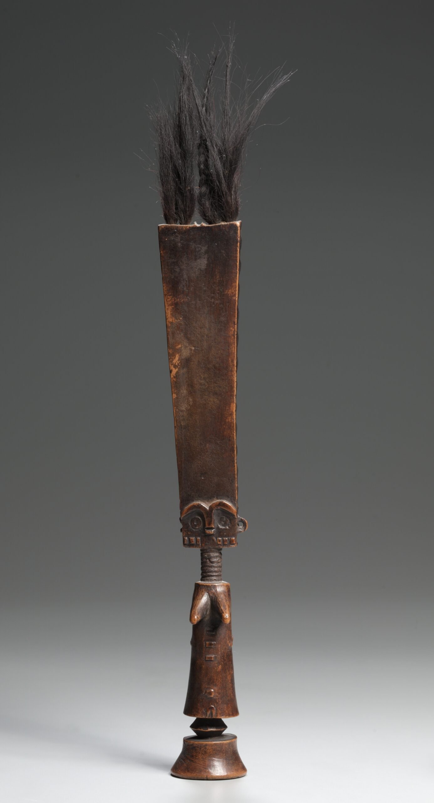 Tall, stylized wooden akua’ba figure from Ghana with an elongated head, tufts of hair, ringed neck and small torso.